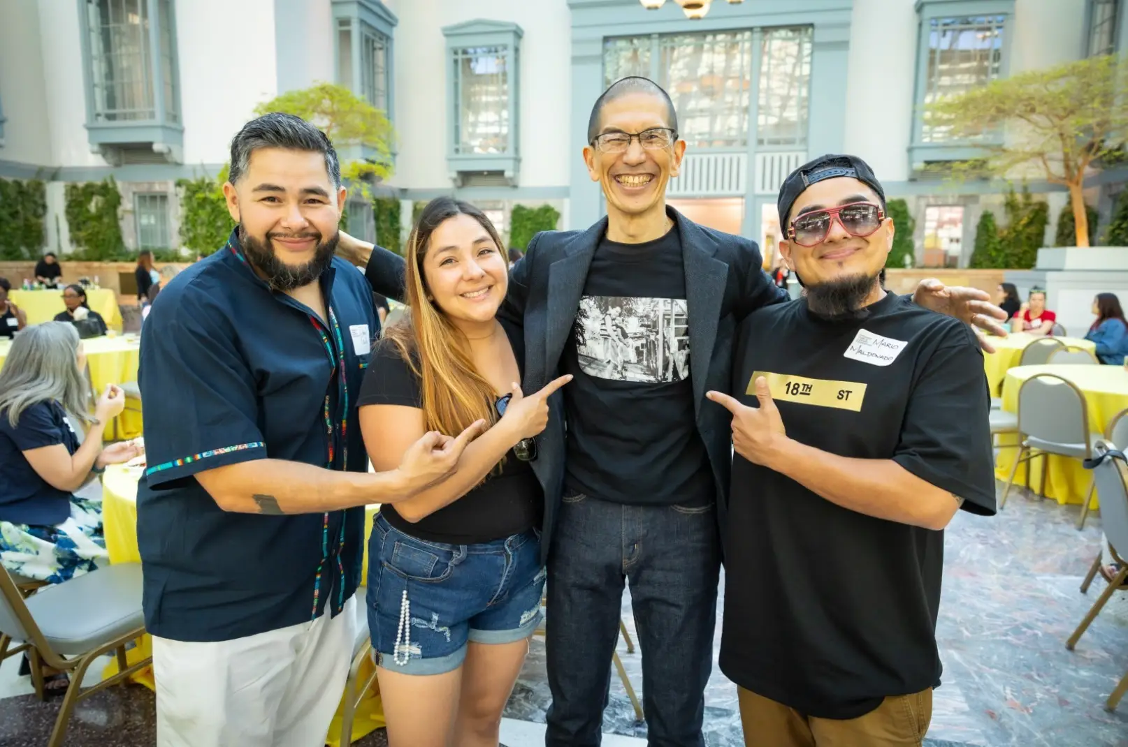 Akito Tsuda and three reception attendees standing side by side smiling.
